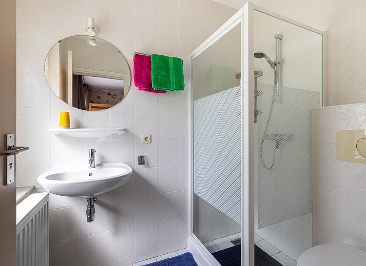 Gemuetliches Wohnzimmer des Ferienhauses Zonnehoek in Exloo, Drenthe, mit grosser Sitzecke und Blick auf die gruene Umgebung.