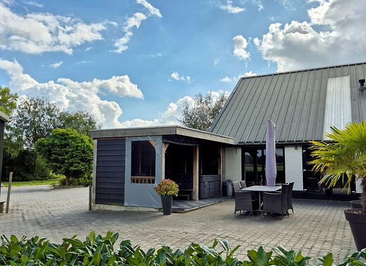 Ontspan op de veranda van het Vakantiehuisje in Dalerveen, Zuidoost Drenthe, met comfortabele ligstoelen en een luxe jacuzzi.