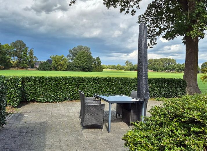 Geniessen Sie die sonnige Terrasse des Ferienhauses in Dalerveen, Suedost-Drenthe, mit bequemen Sitzgelegenheiten und schoener Aussicht auf den Garten.