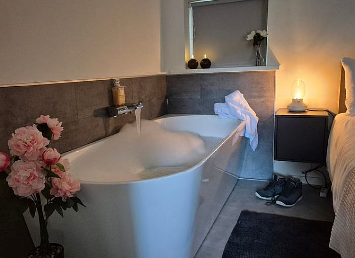 Modernes Badezimmer in Cottage in Dalerveen, Ferienhaus in Sued-Ost-Drenthe mit stilvollem Waschbecken und beleuchtetem Spiegel.