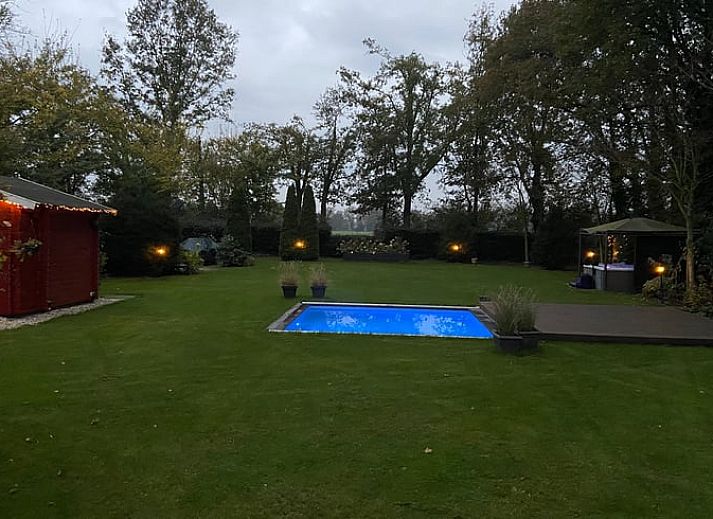 Gemuetliches Wohnzimmer im Ferienhaus in Dalen, Suedost-Drenthe, mit bequemem Sofa und Gartenblick.