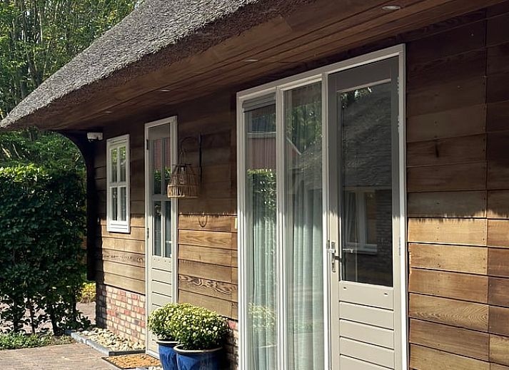 Gezellige entree van Vakantiehuisje in Valthe, Drenthe met rieten dak en houten gevel.