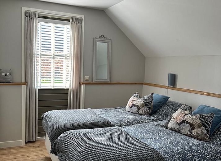 Sfeervolle slaapkamer in Vakantiehuisje in Valthe, Drenthe met comfortabele bedden en decoratieve kussens.