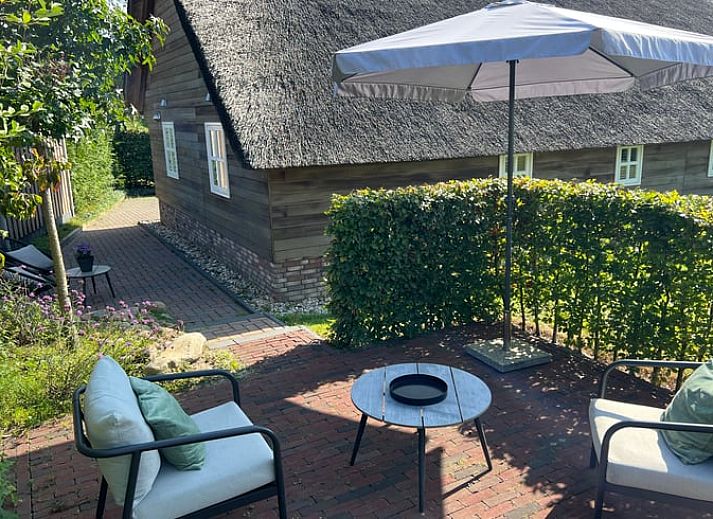 Moderne woonkamer in Vakantiehuisje in Valthe, Drenthe met stijlvolle meubels en decoratie.