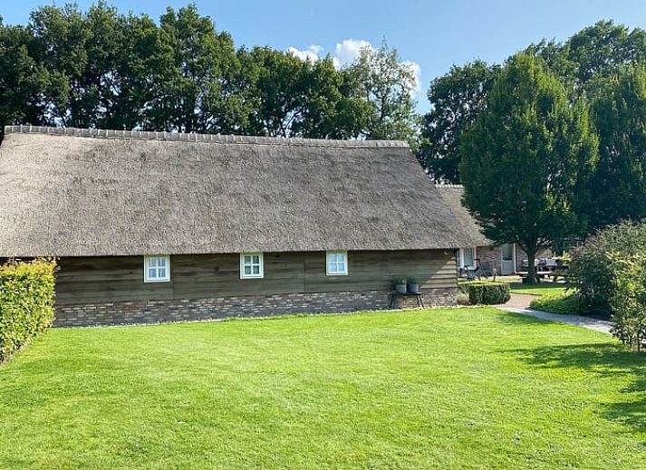 Moderne woonkamer in Vakantiehuisje in Valthe, Drenthe met stijlvolle meubels en decoratie.