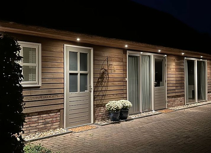 Comfortabele zithoek in Vakantiehuisje in Valthe, Zuidoost Drenthe met zachte kussens en decoratieve elementen.