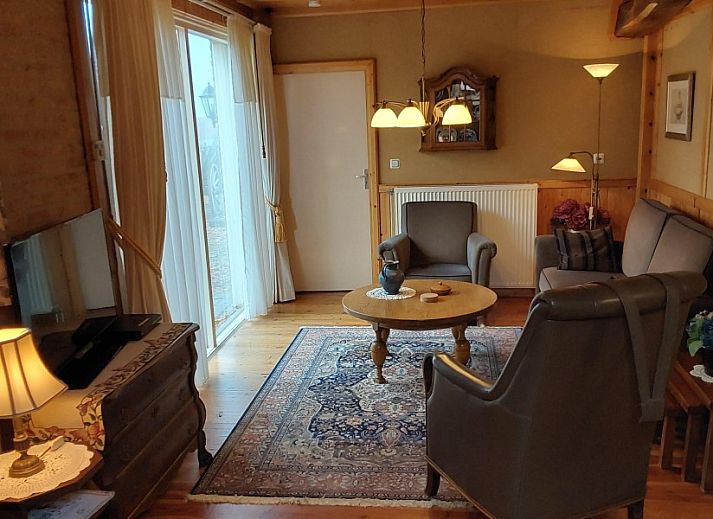 Gemuetliche Terrasse des Bauernhofs Kosterhoeve in Valthe, Suedost-Drenthe, mit Blumen und altem Holzwagen.