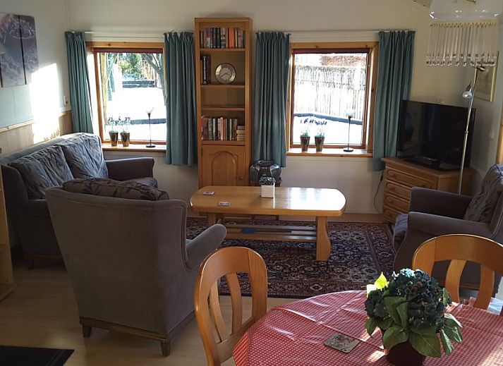 Terrasse und Garten des Boerenhofs in Valthe, Drenthe mit Holzschuppen und Sitzgelegenheit.