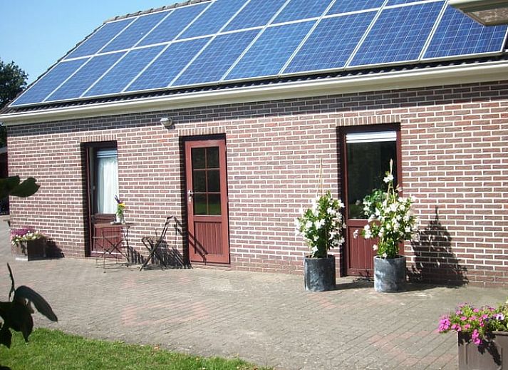 Gemuetlicher Essbereich im Ferienhaus in Valthe, Suedost-Drenthe, mit Blick auf die ruhige Natur durch grosse Fenster.