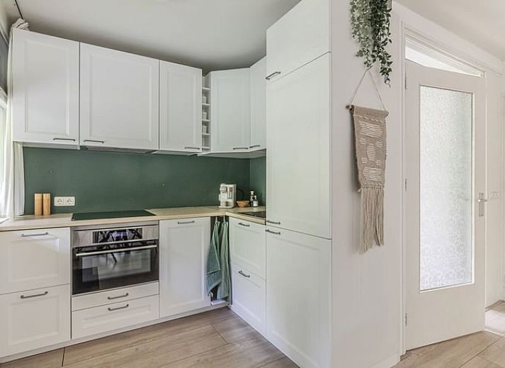 Lichte woonkamer in Vakantiehuis in Schoonoord, Zuidoost Drenthe met moderne inrichting en uitzicht op groene tuin.