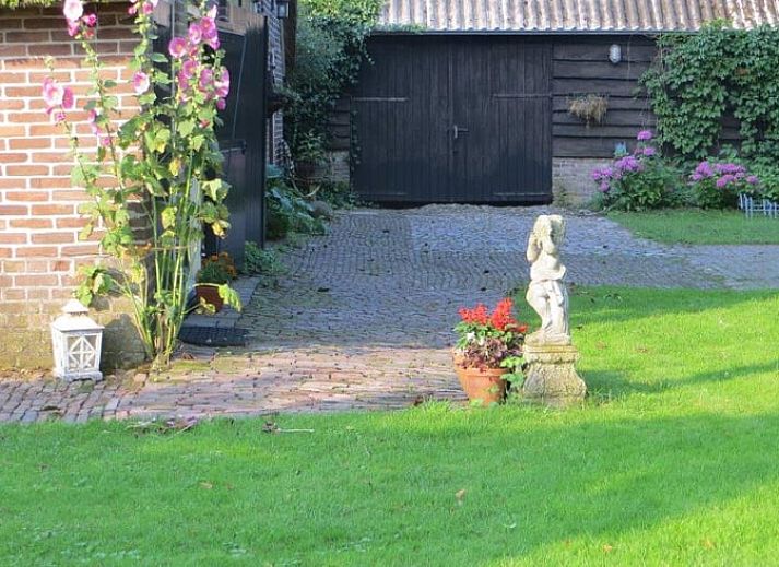 Open deur naar het Huisje in Benneveld, vakantiehuis in Drenthe, omgeven door groen en rust.