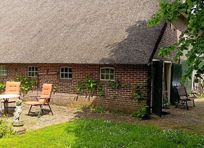 Open deur naar het Huisje in Benneveld, vakantiehuis in Drenthe, omgeven door groen en rust.
