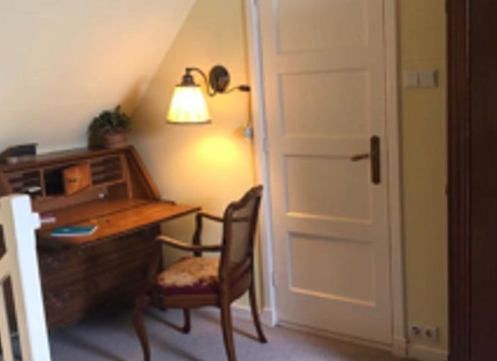 Gezellige leeshoek in Huisje in Benneveld, vakantiehuis in Zuidoost Drenthe met boekenplanken.