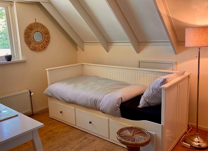 Gemuetliches Esszimmer im Ferienhaus Klijndijk, Drenthe, mit Holztisch und Korbsesseln.