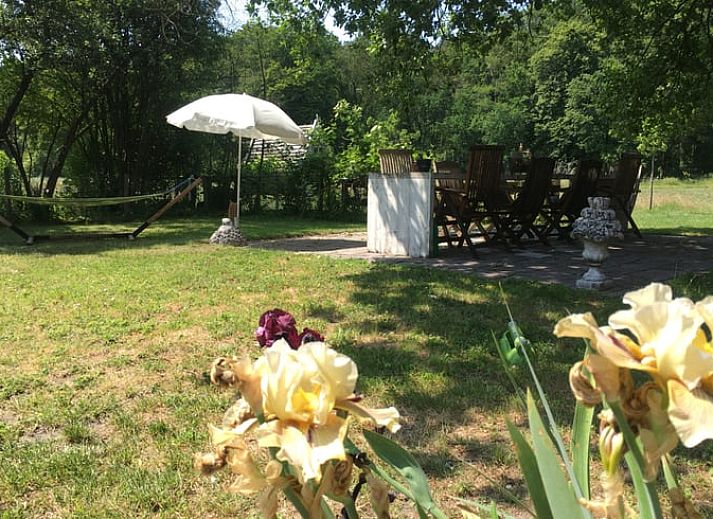 Gemuetliches Esszimmer im Ferienhaus Klijndijk, Drenthe, mit Holztisch und Korbsesseln.
