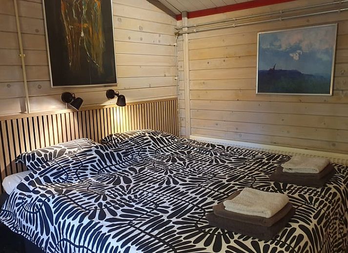 Cozy porch of Holiday Home in 't Haantje, Drenthe, surrounded by flowering shrubs.