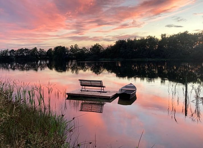 Geniet van de serene zonsondergang bij Vakantiehuisje in Odoornerveen, gelegen aan een idyllisch meer in Zuidoost Drenthe.