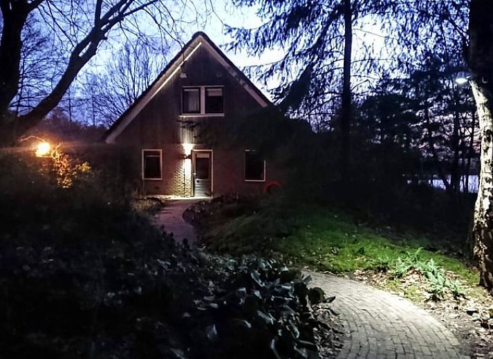 Ontdek het Vakantiehuisje in Odoornerveen, Drenthe, omgeven door weelderige natuur en een uitnodigend pad naar het gastenverblijf.