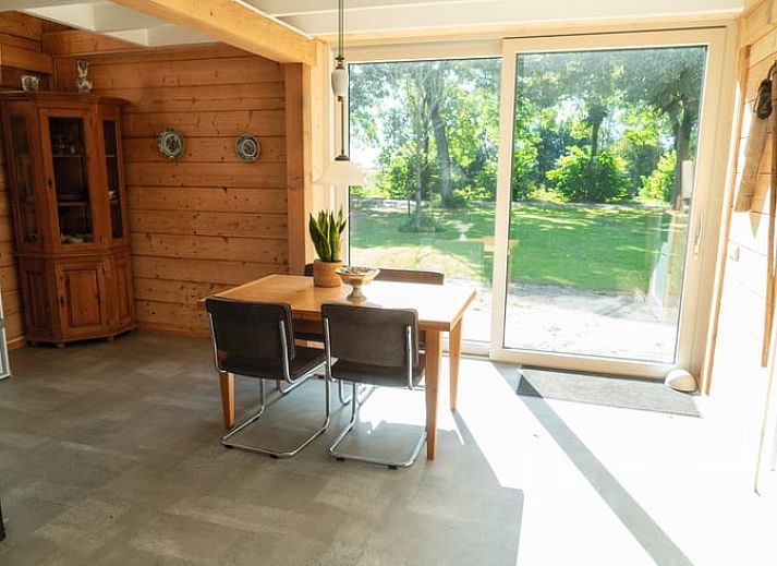Essecke im Ferienhaus in Zwinderen mit Blick auf den gruenen Garten im Suedosten von Drenthe.
