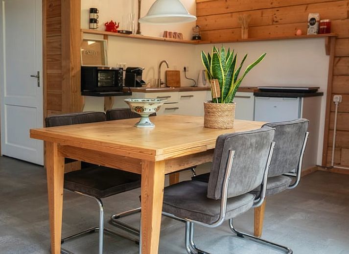 Essecke im Ferienhaus in Zwinderen mit Blick auf den gruenen Garten im Suedosten von Drenthe.