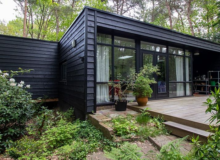 Vacation home in Doldersum, Southwest Drenthe, offers a rustic wooden veranda surrounded by green nature for a relaxing stay.