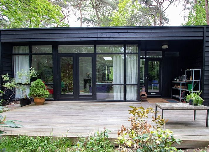 Vacation home in Doldersum, Southwest Drenthe, offers a rustic wooden veranda surrounded by green nature for a relaxing stay.