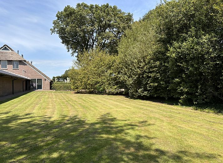 Grosser Garten am Ferienhaus DG1706 in Havelte, Drenthe mit Spielplatz und gruener Hecke.