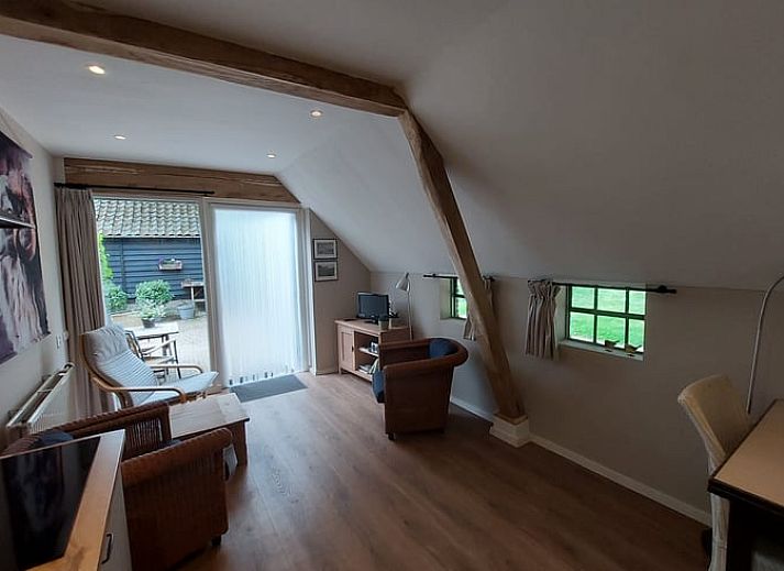 Veranda van Vakantiehuis in Havelte, Zuidwest Drenthe met zitje en groene omgeving.