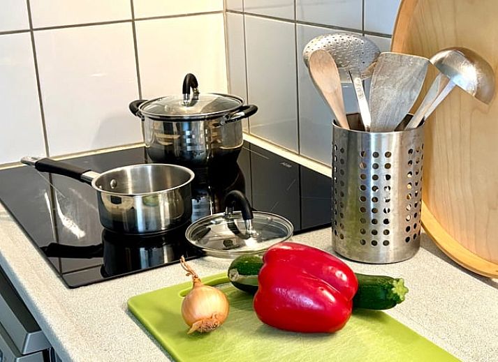 Gemuetliches Wohnzimmer des Ferienhauses in Havelte, Ferienhaus im Suedwesten von Drenthe, mit moderner Einrichtung und Blick auf den gruenen Garten.