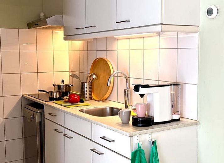 Gemuetliches Wohnzimmer des Ferienhauses in Havelte, Ferienhaus im Suedwesten von Drenthe, mit moderner Einrichtung und Blick auf den gruenen Garten.