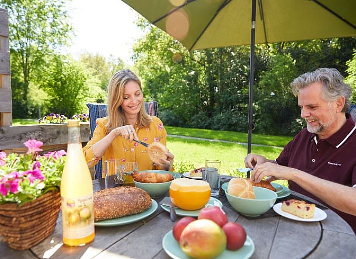 Gemuetliches Wohnzimmer und Kueche des Ferienhauses in Havelte, Ferienhaus im Suedwesten von Drenthe, mit moderner Einrichtung und gemuetlichem Essbereich.