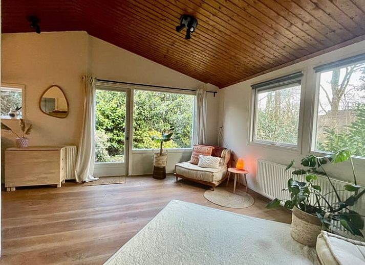 Aussenbereich des Ferienhauses in Havelte, Sued-West Drenthe, umgeben von gruener Natur und Baeumen.