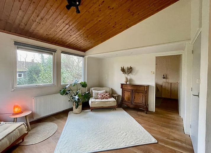 Aussenbereich des Ferienhauses in Havelte, Sued-West Drenthe, umgeben von gruener Natur und Baeumen.