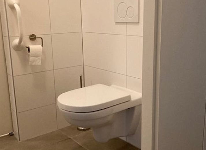 Gemuetlicher Innenbereich des Ferienhauses in Diever, Suedwest-Drenthe, mit einem stimmungsvollen Wohnzimmer und Essbereich.