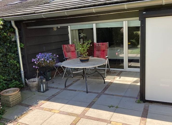 Gemuetlicher Innenbereich des Ferienhauses in Diever, Suedwest-Drenthe, mit einem stimmungsvollen Wohnzimmer und Essbereich.