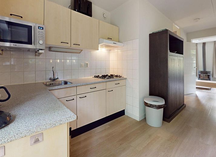 Gezellige eetruimte in vakantiehuis Borre Bos, Diever, met moderne keuken en uitzicht op de groene omgeving van Zuidwest Drenthe.