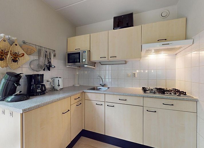 Gezellige eetruimte in vakantiehuis Borre Bos, Diever, met moderne keuken en uitzicht op de groene omgeving van Zuidwest Drenthe.