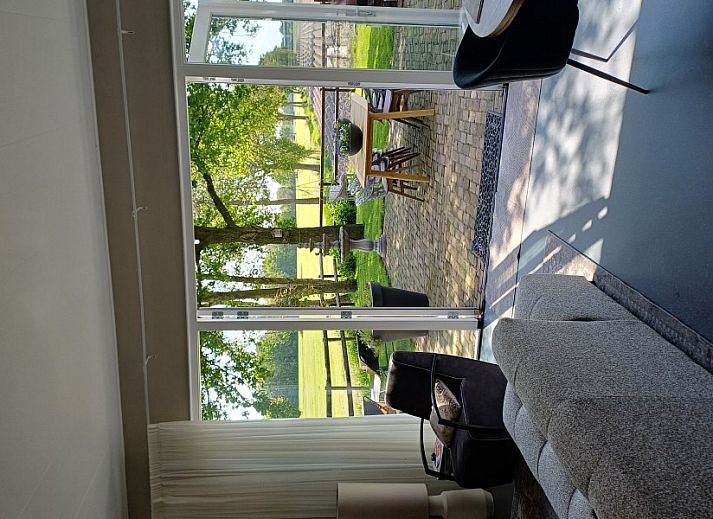Geniet van het uitzicht op de tuin vanaf de veranda van vakantiehuis In 't Westerveld in Zuidwolde, Zuidwest Drenthe.