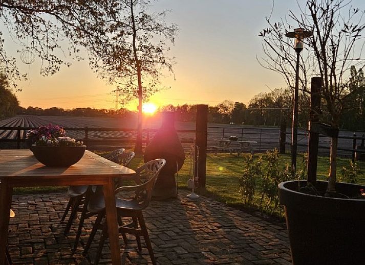 Geniet van het uitzicht op de tuin vanaf de veranda van vakantiehuis In 't Westerveld in Zuidwolde, Zuidwest Drenthe.
