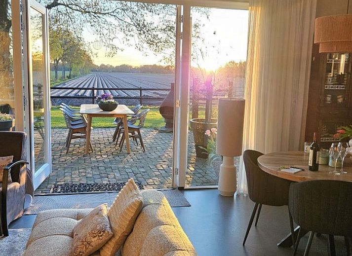Geniet van het uitzicht op de tuin vanaf de veranda van vakantiehuis In 't Westerveld in Zuidwolde, Zuidwest Drenthe.