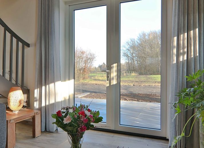 Gezellige woonkamer in Vakantiehuis in Zuidwolde, Drenthe met moderne inrichting en houten plafond.