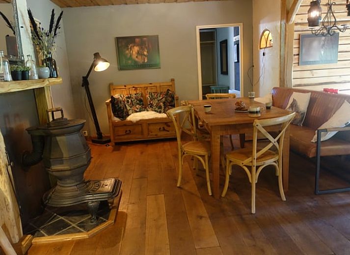 Gezellige woonkamer van Huisje in Zuidwolde, Drenthe, met rustieke inrichting en uitzicht op de groene omgeving.