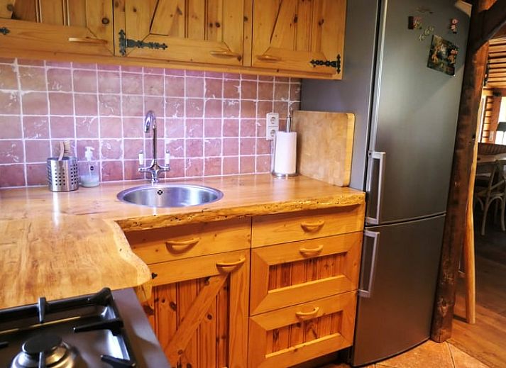 Gezellige woonkamer van Huisje in Zuidwolde, Drenthe, met rustieke inrichting en uitzicht op de groene omgeving.