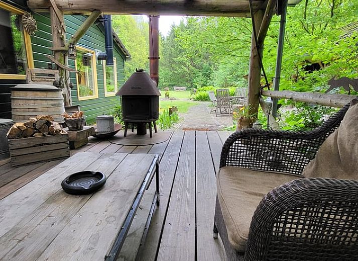 Gezellige woonkamer van Huisje in Zuidwolde, vakantiehuis in Zuidwolde, Drenthe, met houten interieur en uitzicht op de tuin.