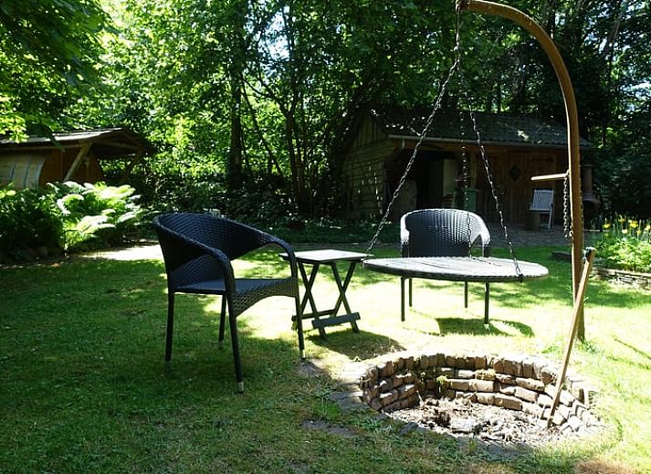 Gezellige woonkamer van Huisje in Zuidwolde, vakantiehuis in Zuidwolde, Drenthe, met houten interieur en uitzicht op de tuin.