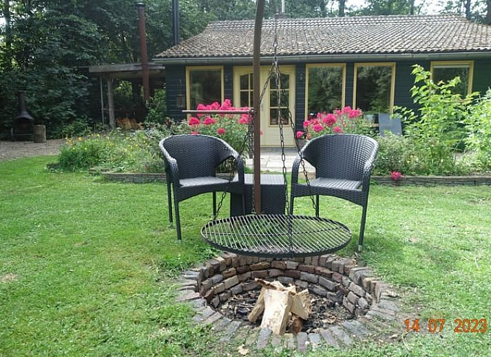 Gezellige woonkamer van Huisje in Zuidwolde, vakantiehuis in Zuidwolde, Drenthe, met houten interieur en uitzicht op de tuin.