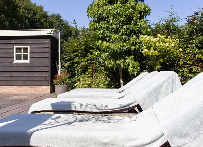 Stilvolles Wohnzimmer im Ferienhaus in Ruinen, Suedwest-Drenthe, mit bequemer Sitz- und Essecke, ideal zum Entspannen.