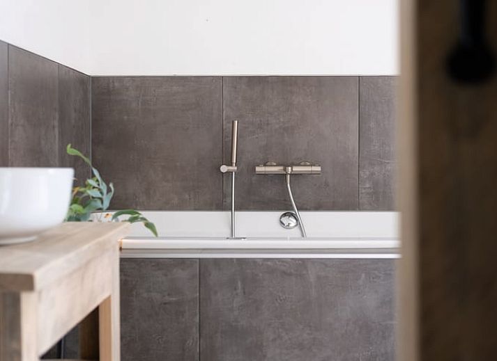 Entspannen Sie sich im Garten von Huisje in Ruinen, einem Ferienhaus im Suedwesten von Drenthe mit Haengematte und Terrasse inmitten gruener Natur.