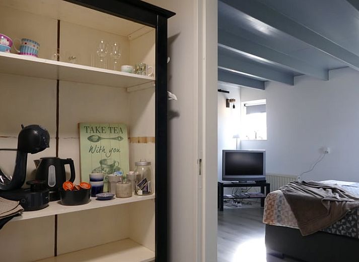 Gemuetlicher Innenbereich des Ferienhauses in Ruinen, Suedwest-Drenthe, mit laendlichem Wandbild und gemuetlicher Sitzecke.