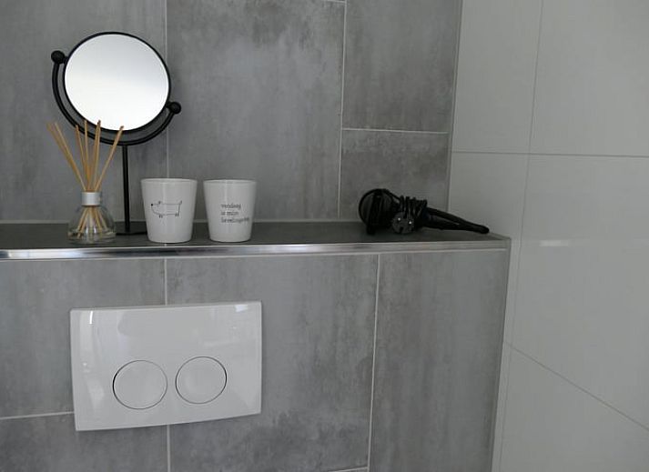 Gemuetlicher Innenbereich des Ferienhauses in Ruinen, Suedwest-Drenthe, mit laendlichem Wandbild und gemuetlicher Sitzecke.